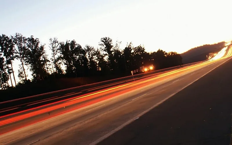 Blurred oncoming headlights streaking across a highway at night Blurred oncoming headlights streaking across a highway at night