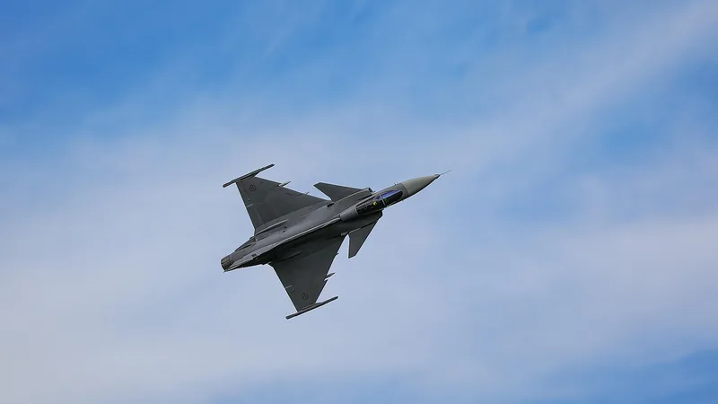 Saab JAS 39 Gripen fighter jet in flight against a blue sky