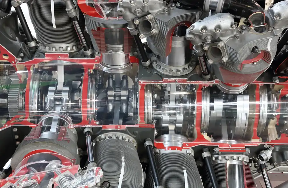 Cutaway view of a piston engine with clear panels showing the crankshaft area and cylinders