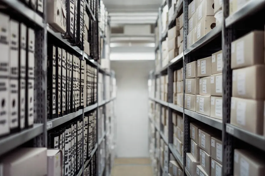 Archive shelves with labeled boxes and binders for long-term records