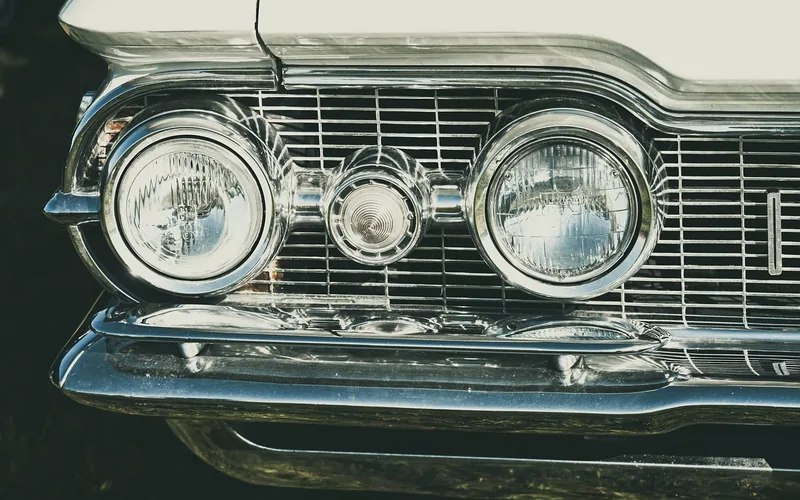 Close-up of chrome dual headlights and grille on an early-1960s American luxury convertible Close-up of chrome dual headlights and grille on an early-1960s American luxury convertible