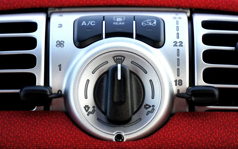 Close-up of a car's dashboard AC vents and climate control panel Close-up of a car's dashboard AC vents and climate control panel