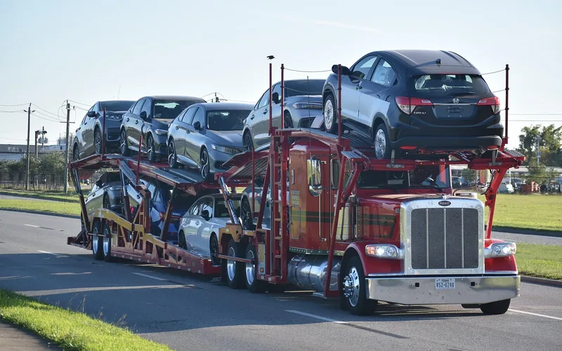 A multi-car carrier truck transporting new vehicles to a dealership