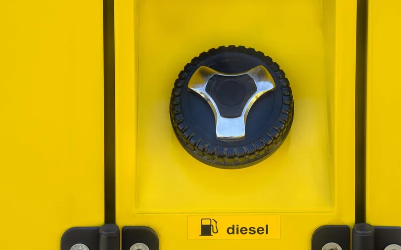 Close-up of an open fuel filler cap and filler neck on a vehicle