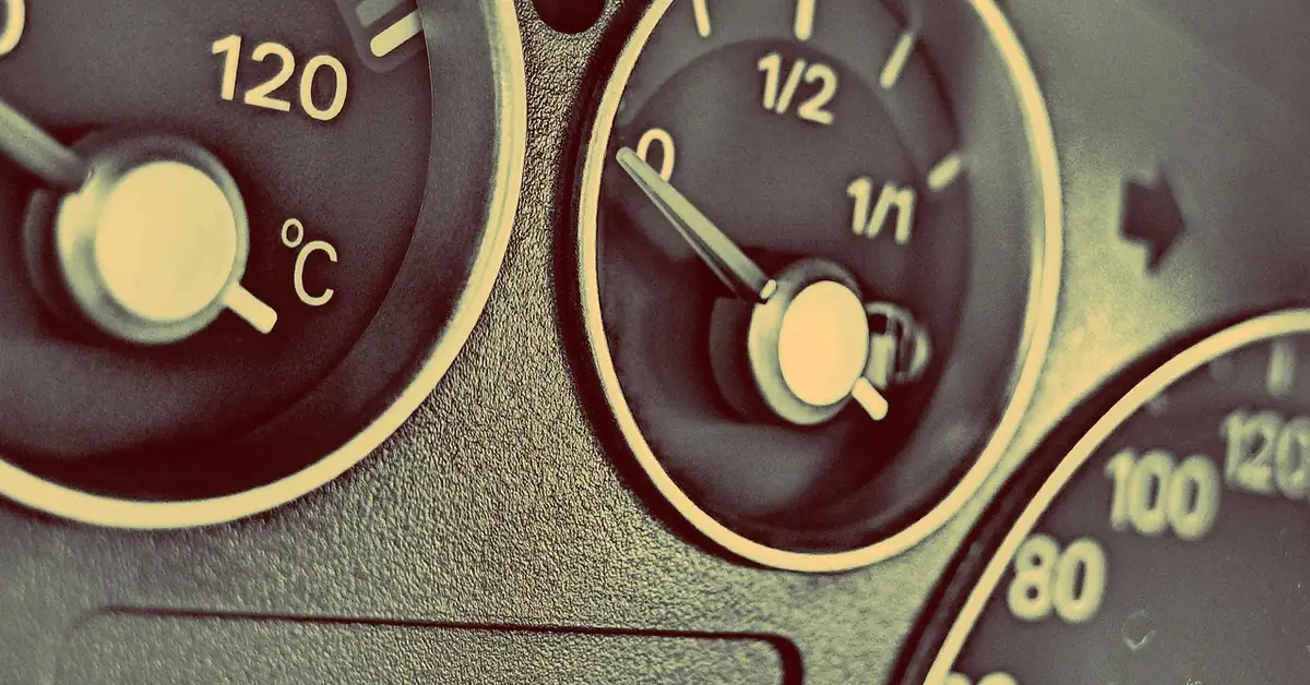 Car dashboard fuel gauge with the needle resting at empty