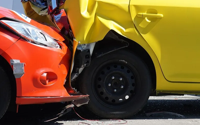 orange car's crumpled front bumper wedged into a yellow car's crushed rear door panel after a crash test orange car's crumpled front bumper wedged into a yellow car's crushed rear door panel after a crash test