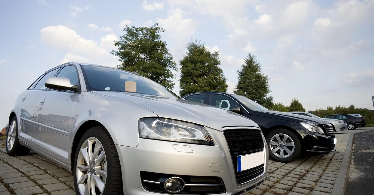 New and used vehicles parked in rows on a car dealership lot