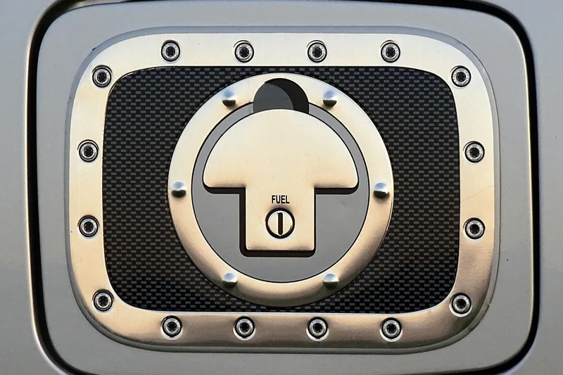 Metal fuel filler cap sitting under an open fuel door