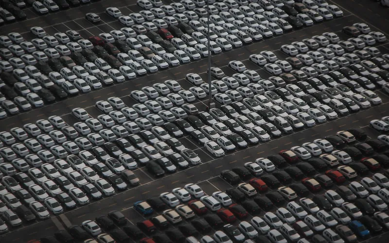 Aerial view of hundreds of new vehicles awaiting manufacturer allocation to dealerships