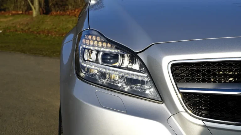 Front corner of a silver car showing the headlamp and grille opening