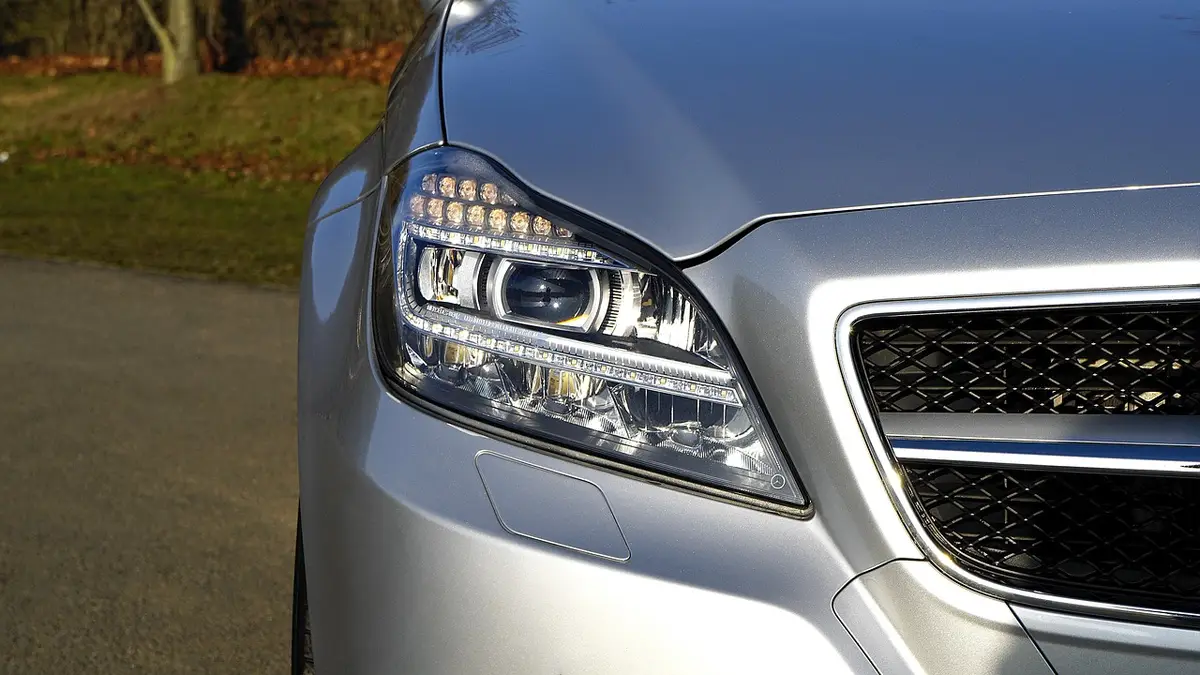 Front corner of a silver car showing the headlamp and grille opening