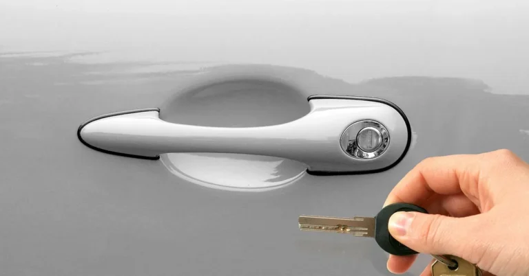 Hand holding a car key at the door handle of a rental vehicle