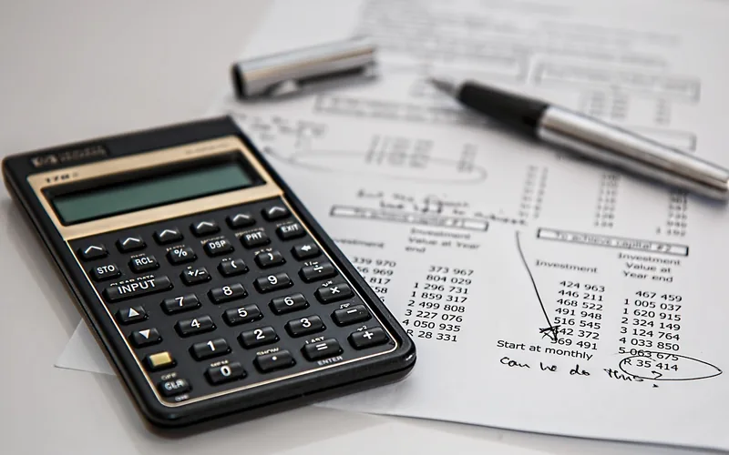 Calculator and financial paperwork used to compare rental car insurance costs
