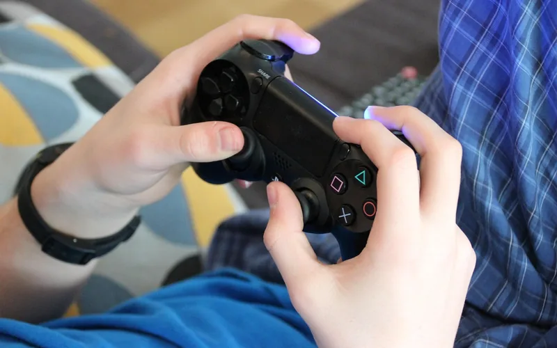 Player holding a console controller while playing a video game