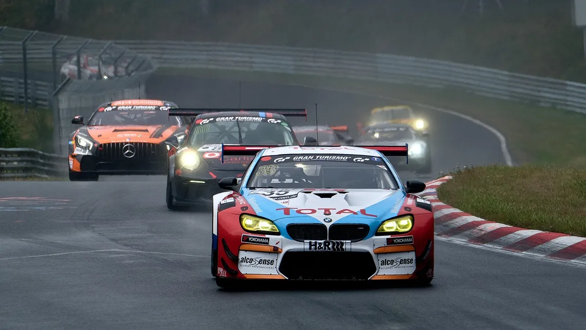 Race cars competing side by side on an asphalt track