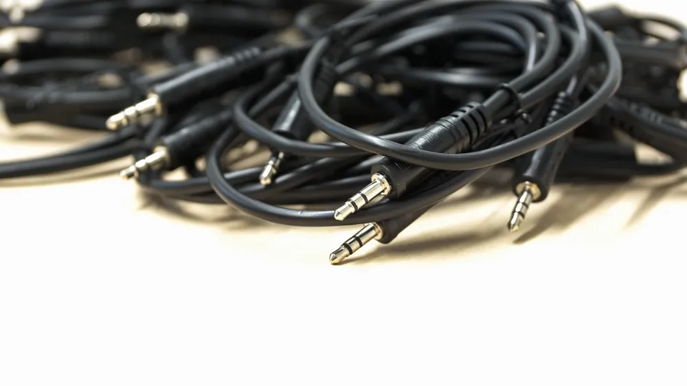 Pile of 3.5 mm AUX audio cables with stereo plugs