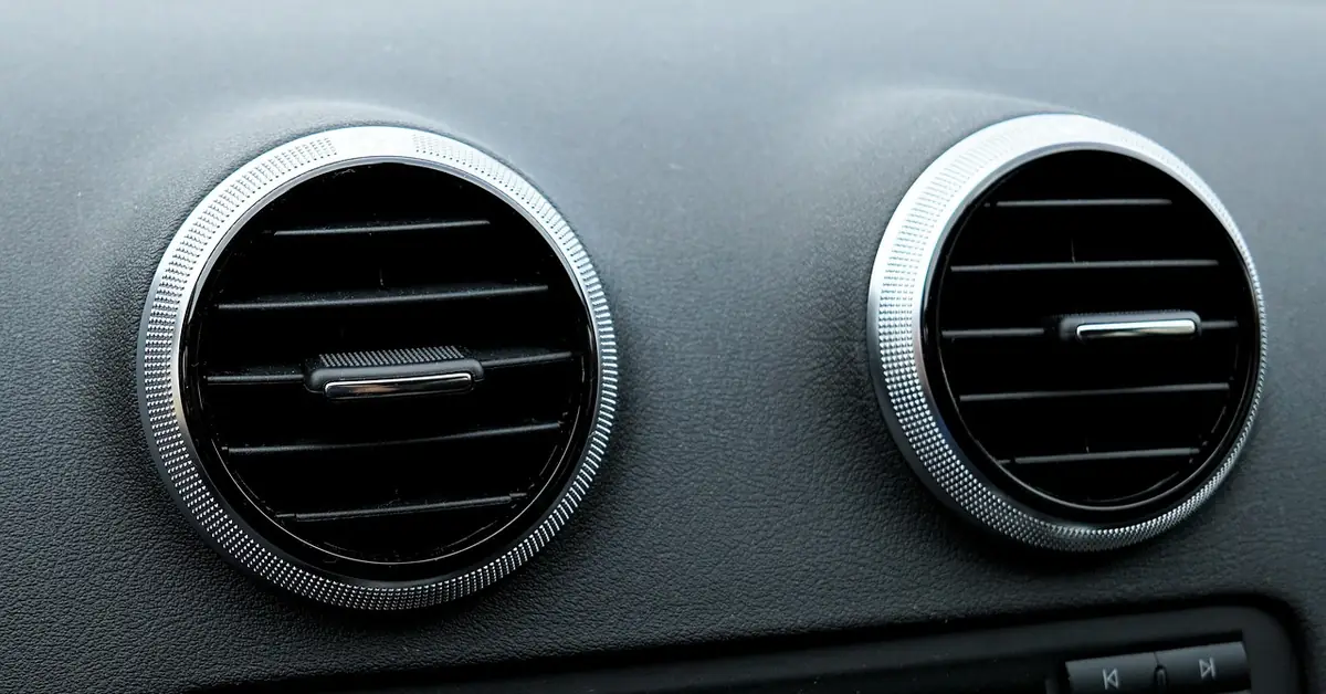 Two round air conditioning vents on a car dashboard