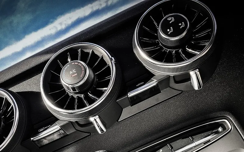 Round chrome-ringed dashboard air vents in a car interior