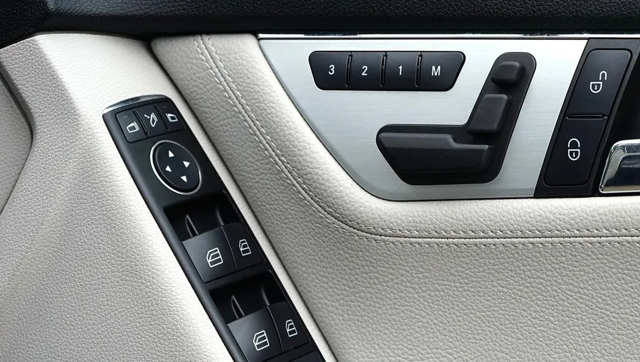Car door panel with power lock and unlock buttons beside the window switches