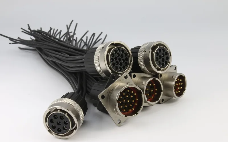 Circular multi-pin connectors with knurled coupling rings on bundled black cables Circular multi-pin connectors with knurled coupling rings on bundled black cables