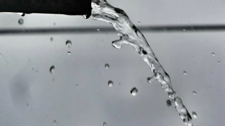 Water dripping and flowing out of a drain pipe end