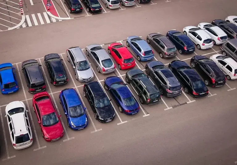 Aerial view of passenger cars parked in rows in a large parking lot