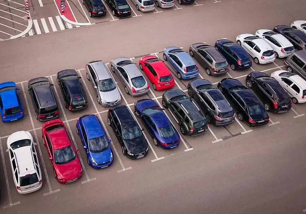 Aerial view of passenger cars parked in rows in a large parking lot