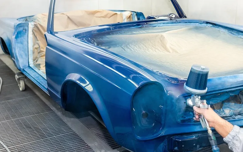 Applying automotive primer to a sanded car panel