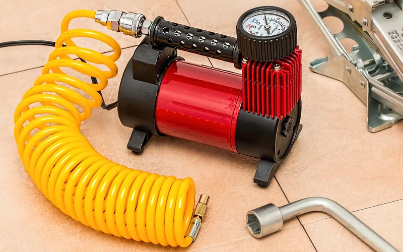 Pressure hose and compressor used to check car AC system for leaks