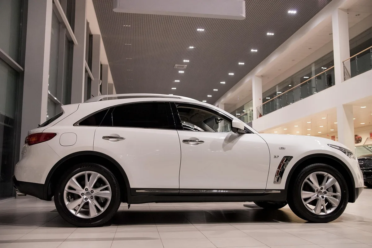 New cars in a dealership showroom showing popular neutral car color choices like white and silver