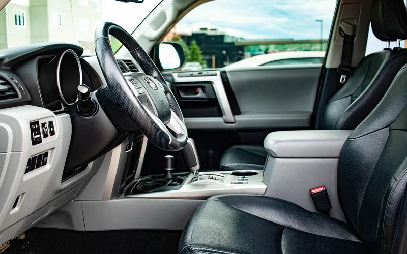 Car interior detailing tools including microfiber towels, brushes, and spray cleaners laid out