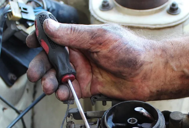 Using a screwdriver to secure a car sun visor to its mounting bracket