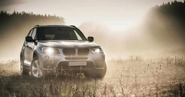 BMW X3 luxury SUV parked in a misty field, compared against the Acura MDX