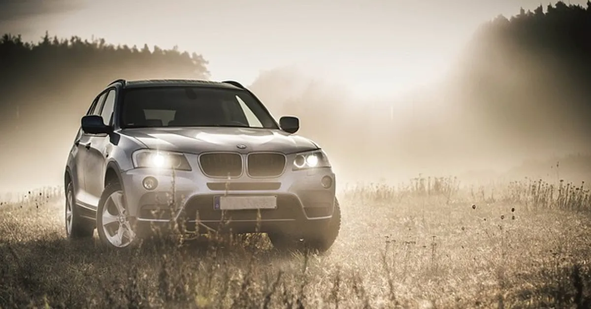 BMW X3 luxury SUV parked in a misty field, compared against the Acura MDX