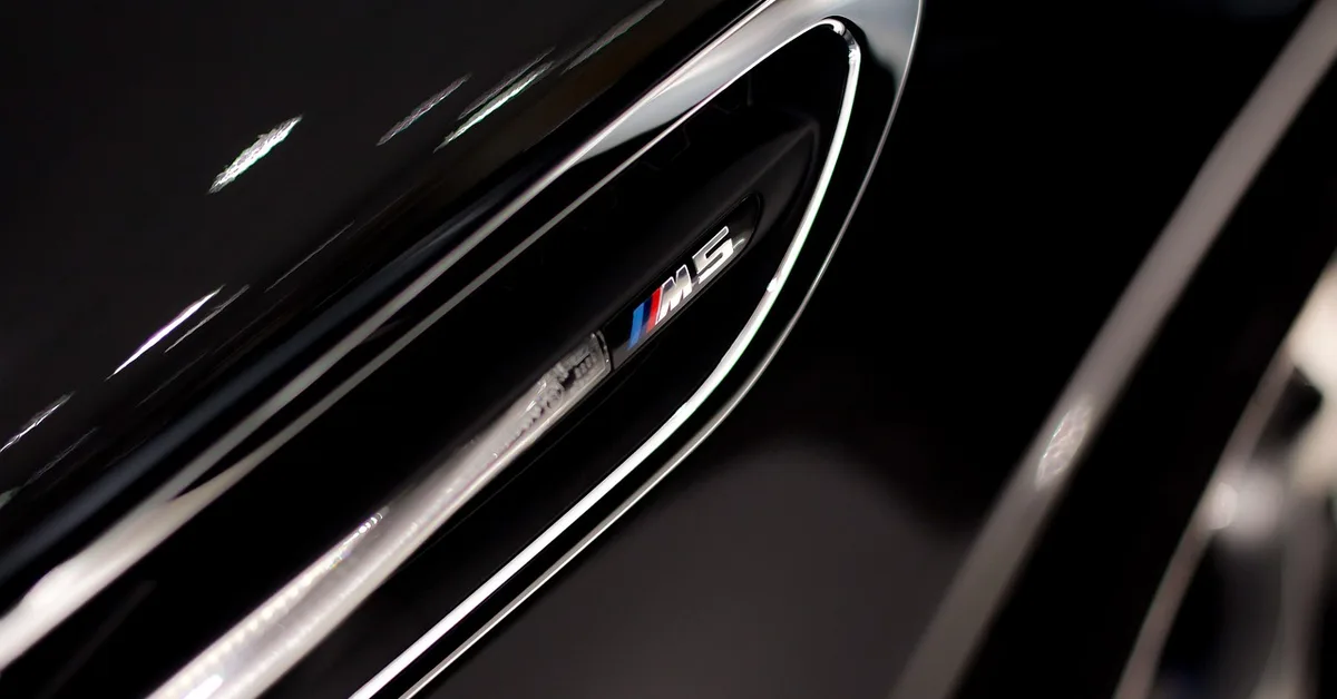 BMW Black Sapphire Metallic badge and body panel with metallic shine