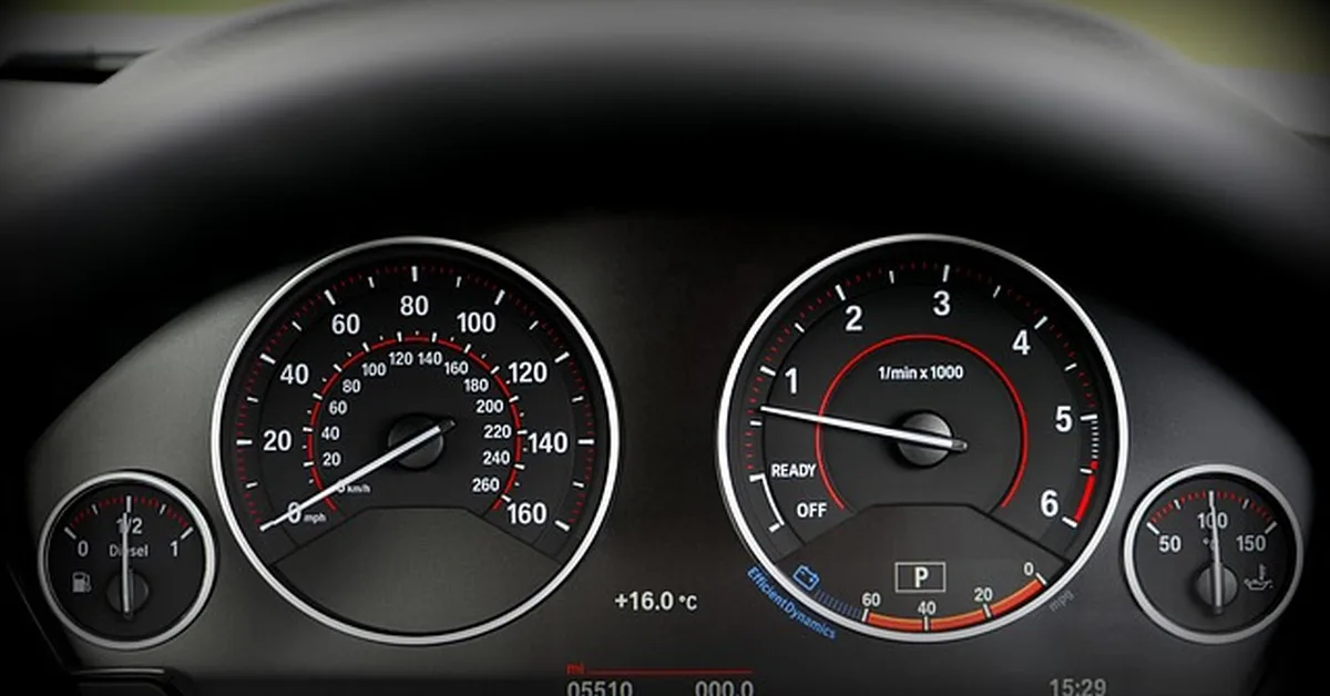 BMW instrument cluster showing speedometer and tachometer gauges where warning messages appear