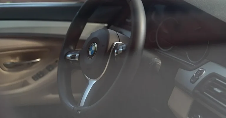 BMW steering wheel and dashboard showing the driver controls