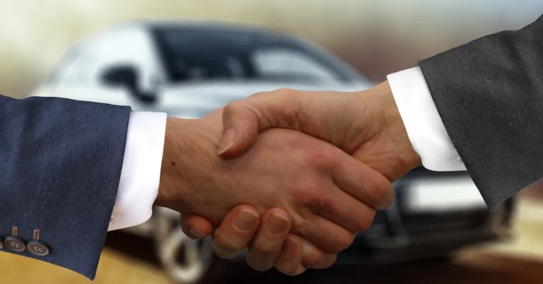 Handshake between a car buyer and a dealer over a purchase