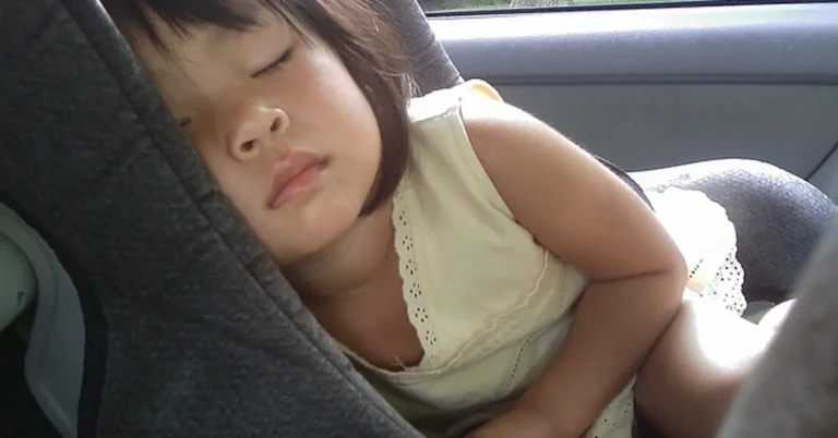 Toddler asleep in a used car seat that meets safety standards
