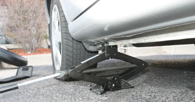 Car being lifted with a wheel removed for tire service