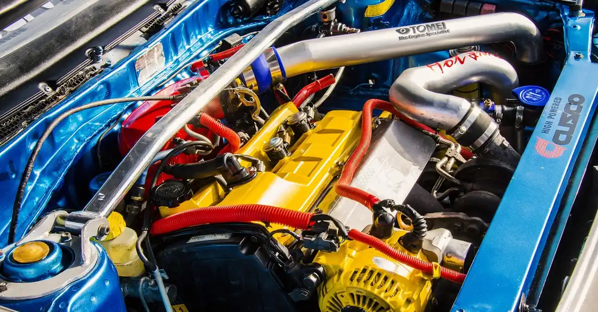 Car engine bay showing the AC compressor