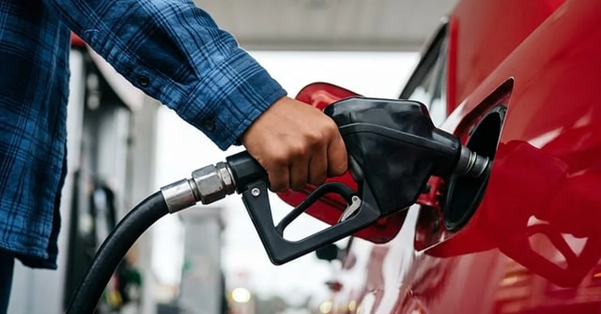Hand fueling a car at a gas station pump