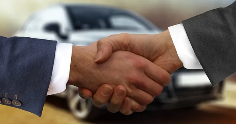 Handshake between a buyer and dealer finalizing a car loan