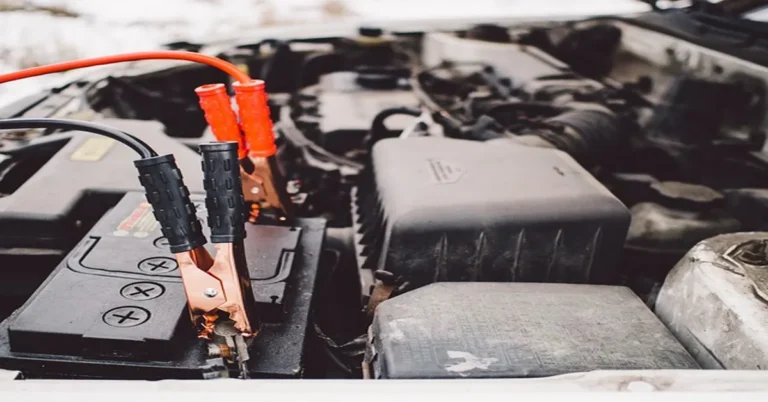 Jumper cables clamped onto a car battery terminal under the hood
