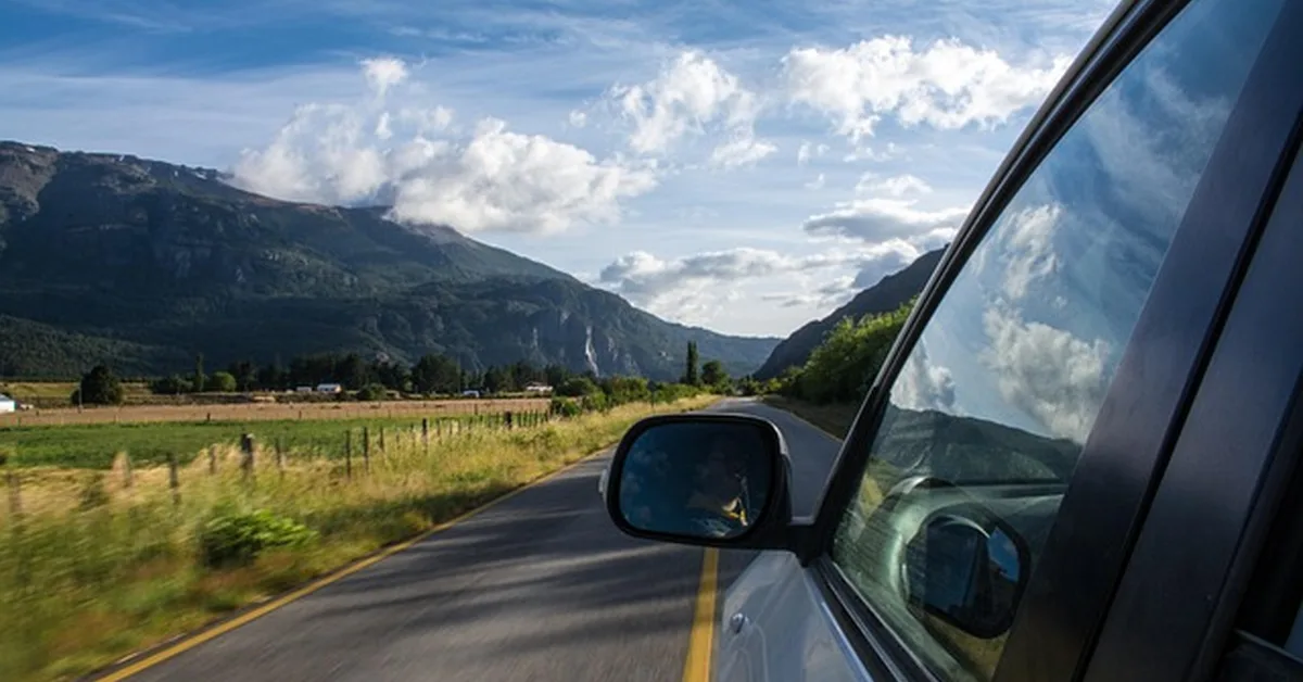 Car side mirror on a mountain road