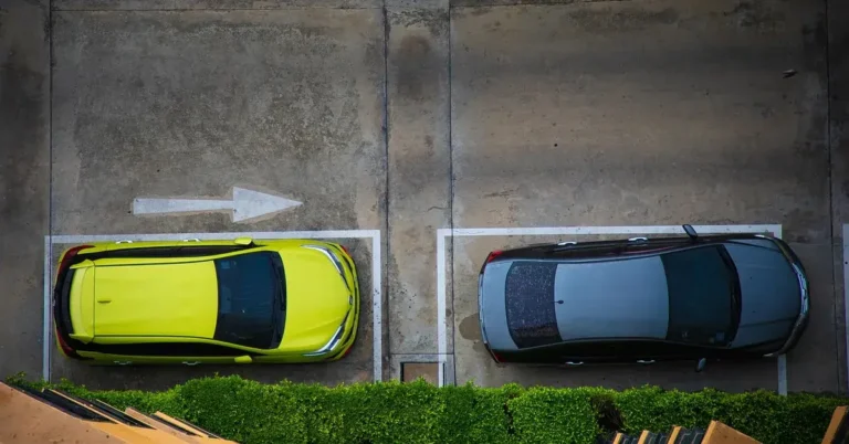 Aerial view of two cars parked in marked spaces