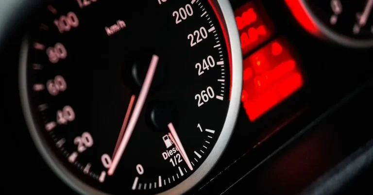 Close-up of a car dashboard speedometer showing the speed limit sign display feature