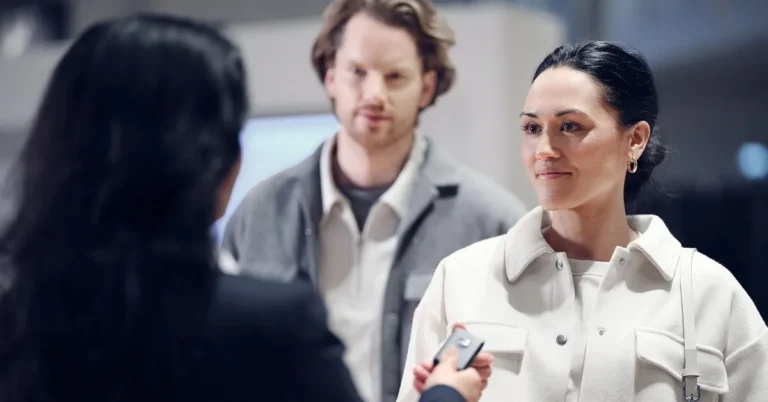 A car buyer receiving a key fob from a dealership representative