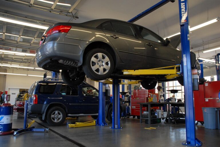 Honda sedan lifted on a dealership service bay hoist for maintenance