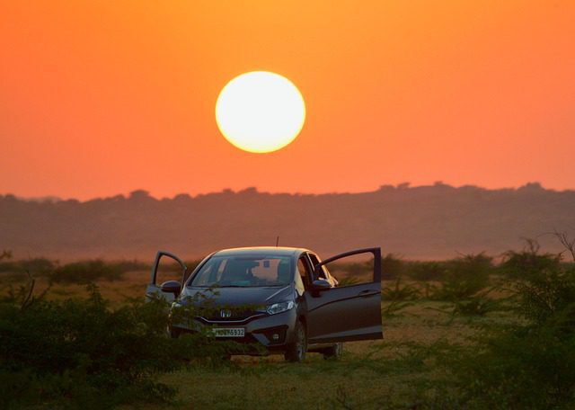 Honda Fit hatchback at sunset, comparing Sport and Base trims